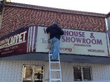 man working on old movie marquee